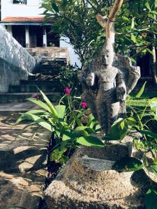 a statue of a person standing next to some plants at GODDESS Kandy in Kandy