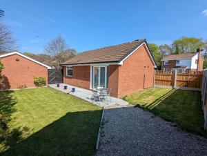 una casa de ladrillo con un patio con una valla en THE KILSYTH,detached bungalow Warrington, en Warrington