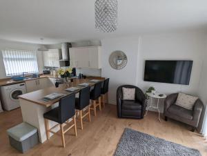 a kitchen with a table and chairs and a kitchen with a tv at THE KILSYTH,detached bungalow Warrington in Warrington