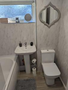 a bathroom with a sink and a toilet and a mirror at THE KILSYTH,detached bungalow Warrington in Warrington