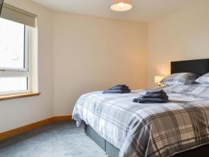 a bedroom with a bed in a room with a window at Aurora in Lossiemouth