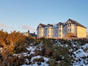 a large building on top of a hill in the snow at Aurora in Lossiemouth