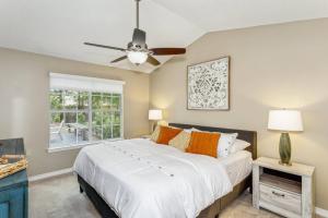 a bedroom with a bed and a ceiling fan at Sunrunner Cottage in Pensacola