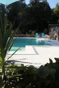 a large swimming pool with blue chairs in a yard at Studio with shared pool and wifi at Marco de canaveses in Marco de Canaveses