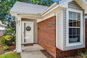 a brick house with a white door and a porch at Sunrunner Cottage in Pensacola +26 photos