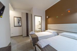 una camera d'albergo con due letti e un bagno di Residenza Digione a Parma