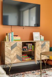 a wooden entertainment unit with a television on a wall at NEW HAPPY TRAIL 2BR CONDO CLOSE TO DOWNTOWN in Traverse City +33 photos