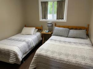 1 dormitorio con 2 camas y ventana en Rivers End Motel, en Corner Brook