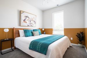 a bedroom with a large bed with blue pillows at NEW HAPPY TRAIL 2BR CONDO CLOSE TO DOWNTOWN in Traverse City