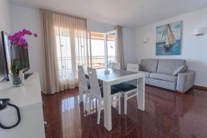 a living room with a table and chairs and a couch at Beach Family Apartments in Salou