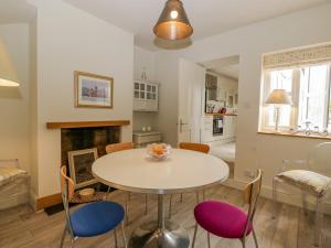 een keuken en een woonkamer met een tafel en stoelen bij Primrose Cottage in Cheltenham