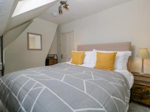 een slaapkamer met een groot bed met gele kussens bij Primrose Cottage in Cheltenham