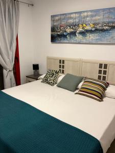 un letto con due cuscini e un dipinto sul muro di Anna’s apartment a Benidorm