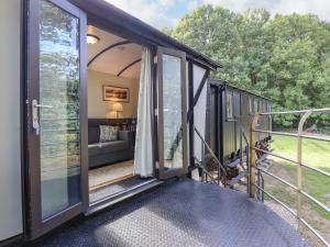 une véranda couverte d'une petite maison dans l'établissement The Brake Wagon at High Barn Heritage, à Halstead