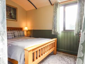 une chambre avec un lit et une fenêtre dans l'établissement The Brake Wagon at High Barn Heritage, à Halstead