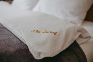 タターリウにあるThe Livingの白い枕(ベッドの上にリビングと書かれた枕)