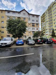 un gruppo di auto parcheggiate di fronte a un edificio di Apartament AMA Sibiu a Sibiu