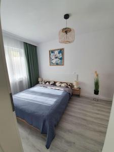 una camera da letto con un grande letto con una coperta blu di Apartament AMA Sibiu a Sibiu
