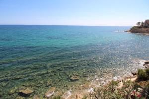 um grande corpo de água com uma praia rochosa em Villa Mar em El Campello