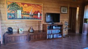 a living room with a television and a entertainment center at Chalet di San Martino in San Martino in Colle