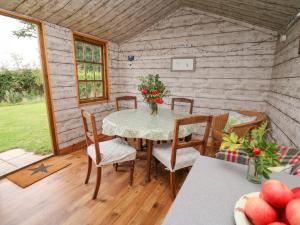 uma sala de jantar com uma mesa e cadeiras num camarote em Sweet Briar Shepherds Hut em Brecon