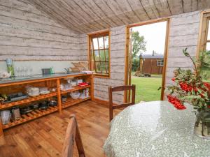 um quarto com uma mesa e um balcão com uma janela em Sweet Briar Shepherds Hut em Brecon