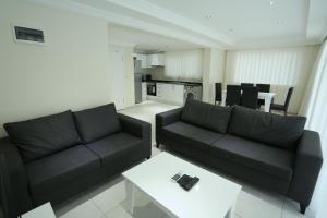 a living room with two black couches and a table at Orka Royal Hills Apartments in Oludeniz