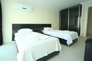 a hotel room with two beds with white sheets at Orka Royal Hills Apartments in Oludeniz