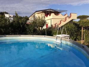 una gran piscina azul frente a una casa en Green Paradise Holidays villa Apartment, en Massa Lubrense
