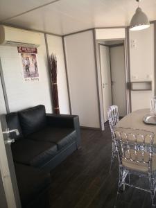una sala de estar con un sofá y una mesa en La Colline des Ocres Village de vacances 3 étoiles, en Apt
