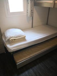 a bed in a bunk room with towels on it at La Colline des Ocres Village de vacances 3 étoiles in Apt