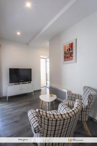 a living room with two chairs and a tv at Chez Welter in Argelès-Gazost