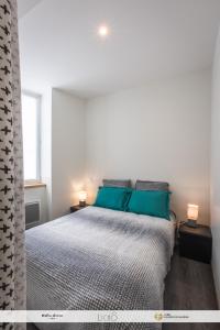 a bedroom with a large bed with blue pillows at Chez Welter in Argelès-Gazost