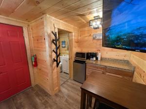a kitchen with a red door in a log cabin at Newly Remodeled Motel in Gatlinburg! in Gatlinburg