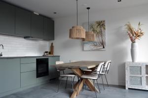 a kitchen with a wooden table and chairs at Have a nice stay! - Olive Beach, luxury beachhouse 150 m from the beach in Noordwijk aan Zee