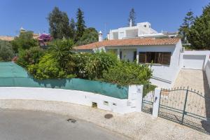 una casa con una recinzione bianca e alcune piante di Villa Emilio Pequena by Villa Plus ad Albufeira