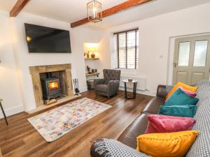 un soggiorno con divano e camino di April Cottage a Keighley