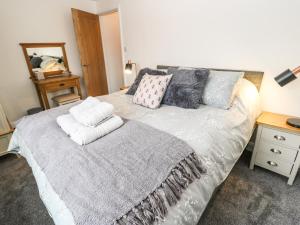 una camera da letto con un letto grande con cuscini sopra di April Cottage a Keighley