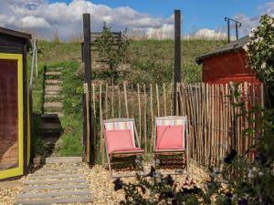 duas cadeiras sentadas em frente a uma cerca em Coastguard Cottage em Rye