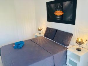 ein Schlafzimmer mit einem Bett und zwei Tischen mit Lampen in der Unterkunft Sunnybeach Apartment mit direktem Strandzugang in Denia
