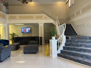 a living room with a staircase with a couch and a tv at Quality Inn Airport Jacksonville in Jacksonville