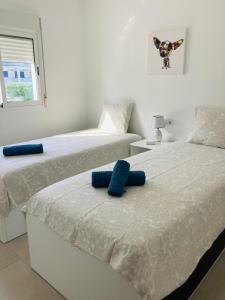 two beds sitting next to each other in a bedroom at Sunnybeach Apartment mit direktem Strandzugang in Denia