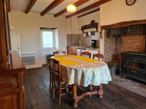 y cocina con mesa, sillas y fogones. en Maison chaleureuse près de Rocamadour, en Alvignac