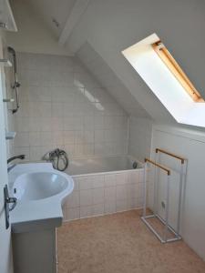 y baño con bañera blanca y lavamanos. en Maison chaleureuse près de Rocamadour, en Alvignac
