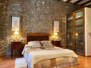 a bedroom with a large bed in a stone wall at Casa rural CAL SERRA in Alentorn
