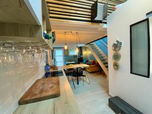 una cucina e una sala da pranzo con tavolo e scale di LOFT BULOT MAYO’S à 200 Mètres de la plage . a Wimereux