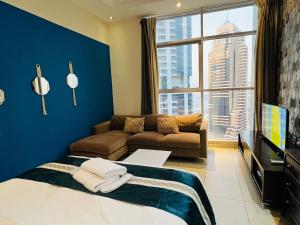 um quarto com uma cama, um sofá e uma janela grande em 3 bedroom marina beach view apartment skyview tower marina no Dubai