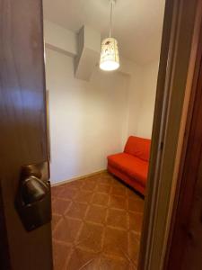 a room with a red couch and a light at Casetta Rivisondoli con Garage gratuito in Rivisondoli