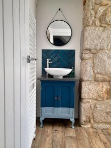 La salle de bains est pourvue d'un lavabo et d'un miroir. dans l'établissement Sea View Cottage in Dorset, Portland, à Portland