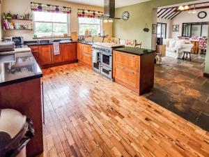 a kitchen with wooden cabinets and a wooden floor at Blashford Manor Farm House in Ellingham